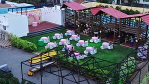 A rooftop venue with multiple seating areas, a stage, and a pool. - Selvam Residency (Thoothukudi)