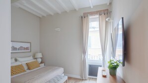 A bedroom with a bed, bedside table, and a window with curtains. - THE BREAK - PIAZZA DI SPAGNA MAISON DELUXE TERRACE (Roma)