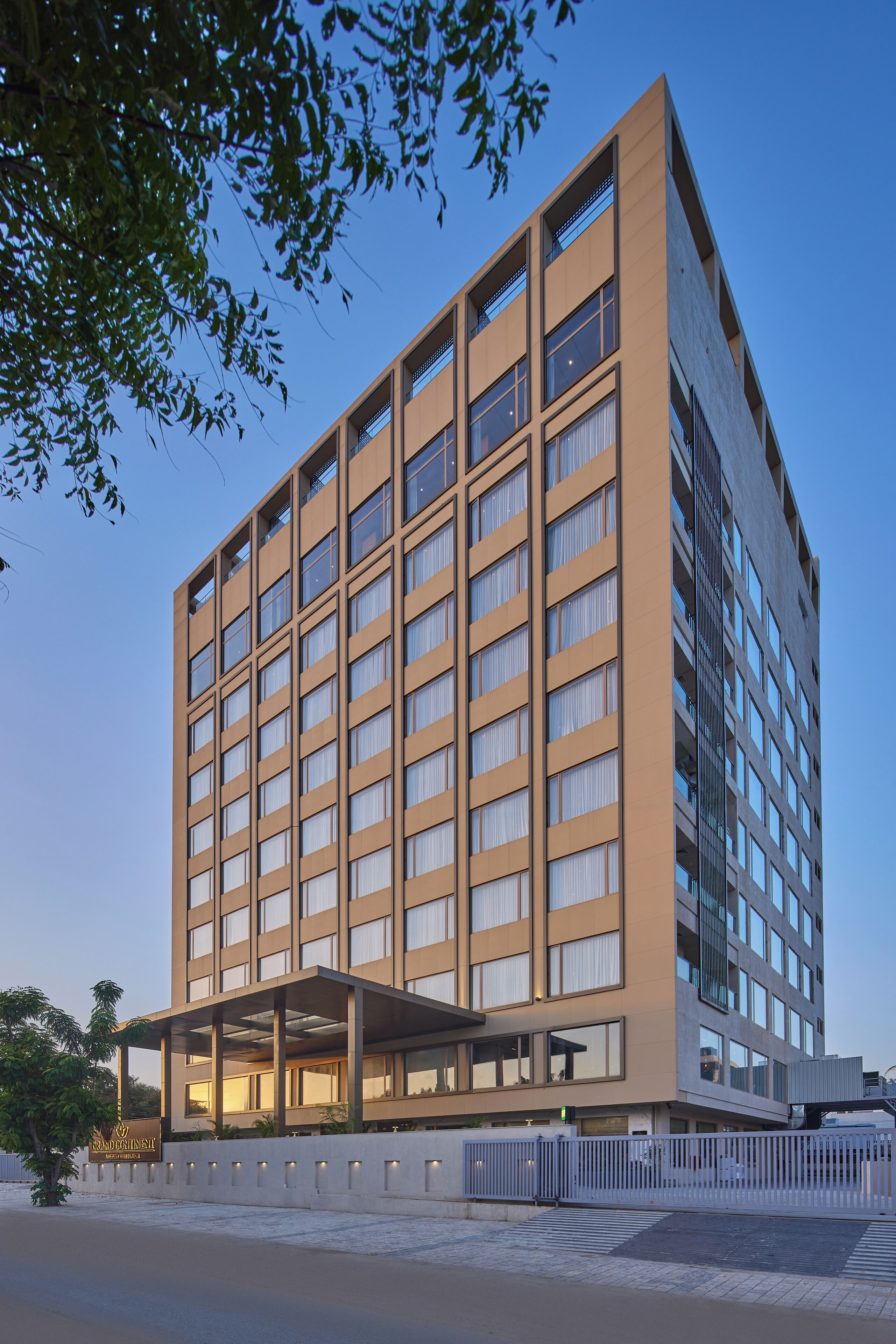 Un hotel moderno de varios pisos con fachada plana, ventanas grandes y una zona de entrada cubierta.