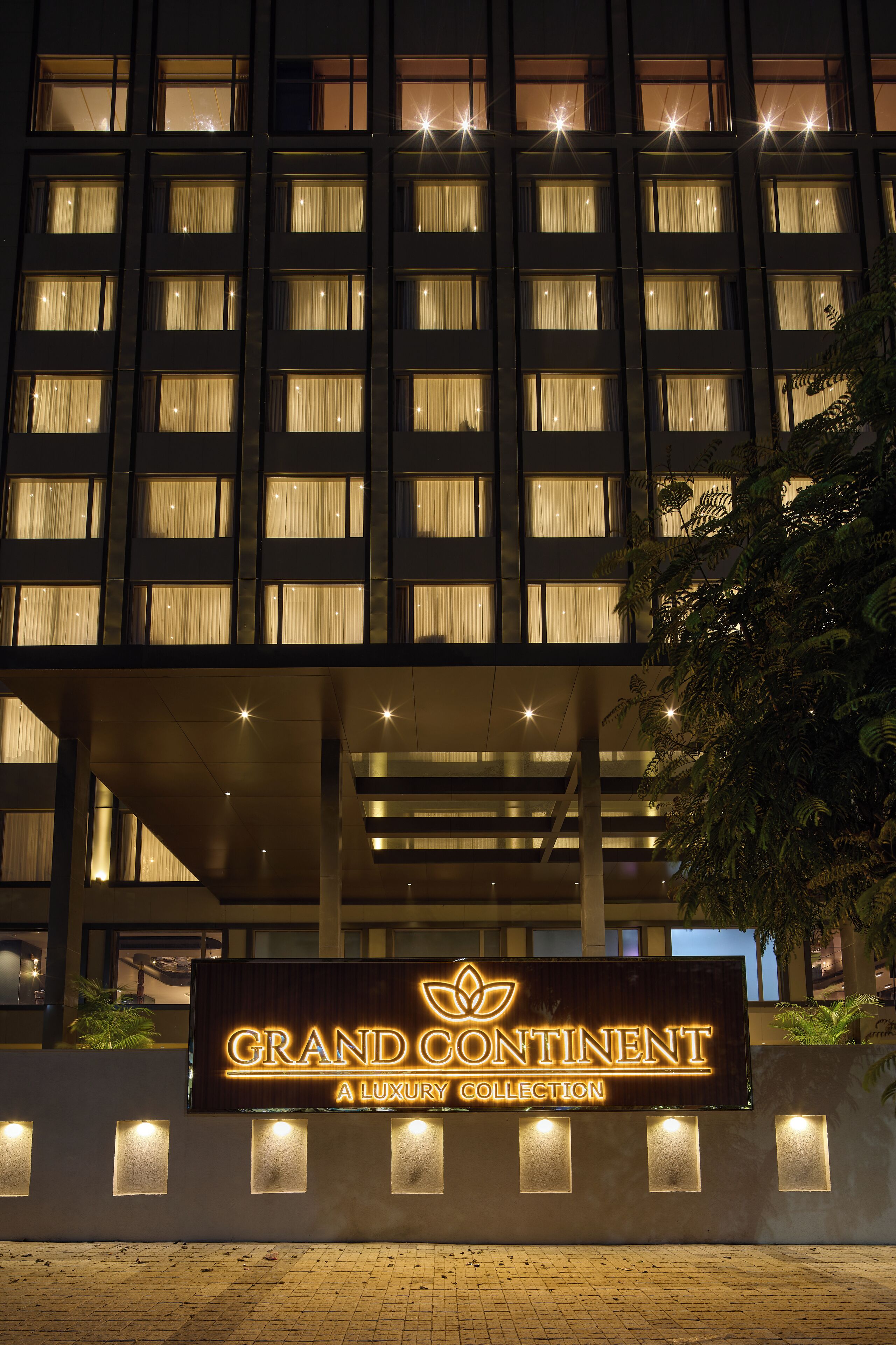 A hotel named "Grand Continent" with a luxury collection sign, multiple floors, and illuminated windows.