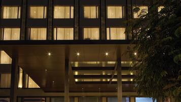 A hotel named "Grand Continent" with a luxury collection sign, multiple floors, and illuminated windows.