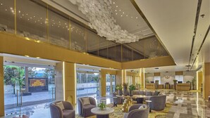 A spacious lobby with modern furniture, a reception desk, and a view of the outside. - Grand Continent- A Luxury Collection Udaipur (Udaipur)