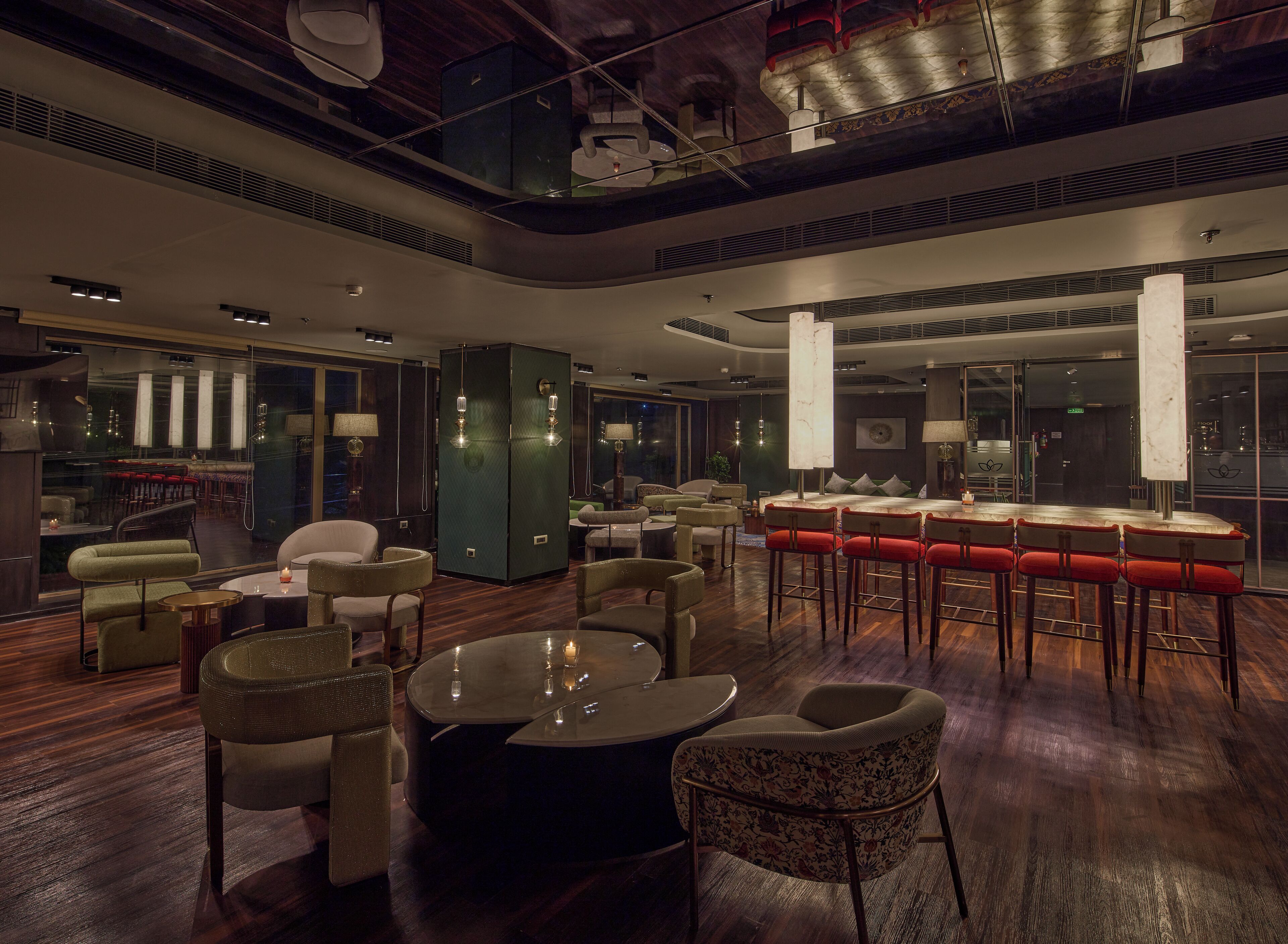 Un hall de hotel espacioso con una zona de bar, arreglos de asientos y vistas del paisaje urbano a través de amplias ventanas.