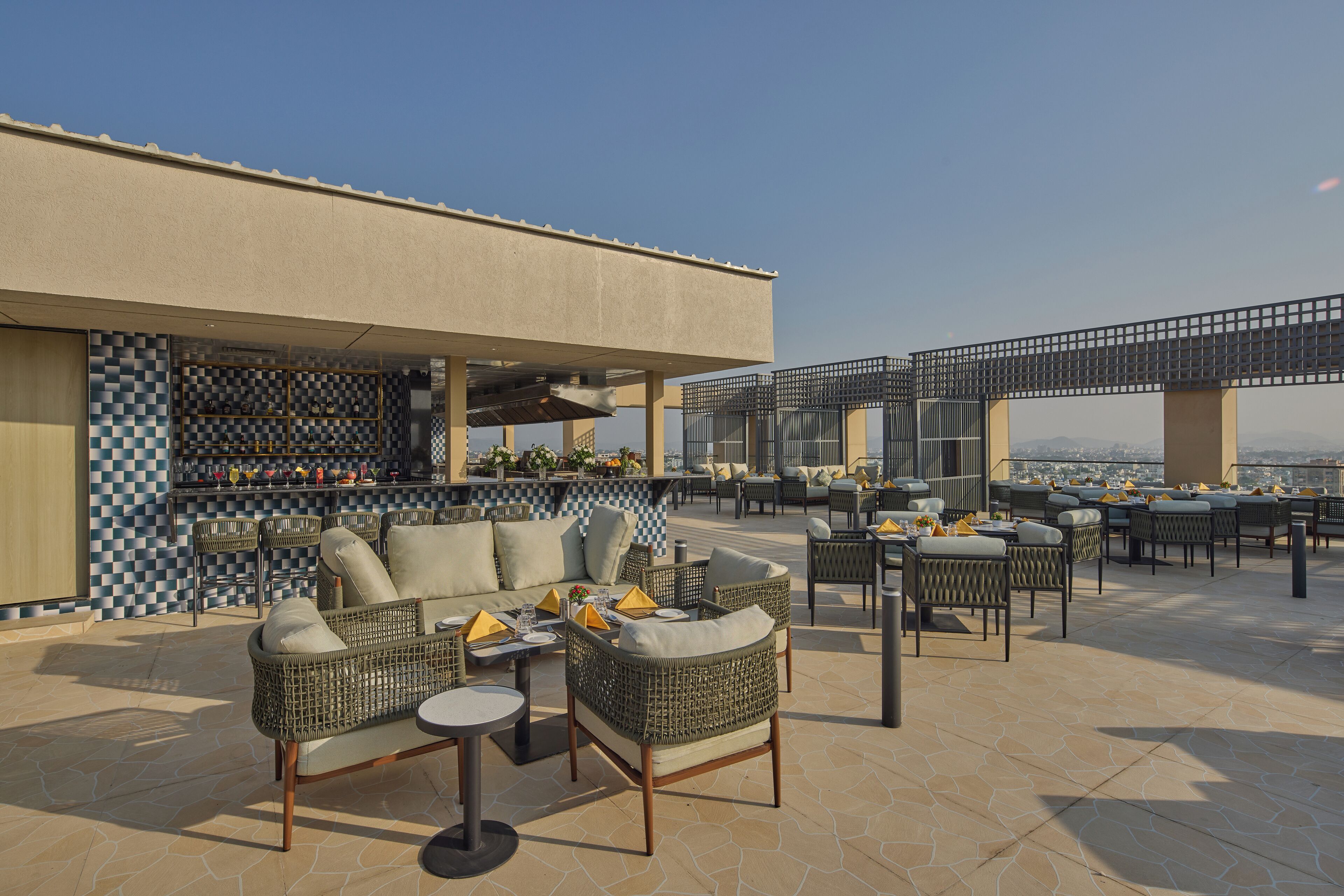 An outdoor seating area with wicker furniture and a bar.