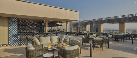 An outdoor seating area with wicker furniture and a bar.