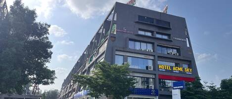 A multi-story building with a sign for "HOTEL ACME SKY" on the ground floor.