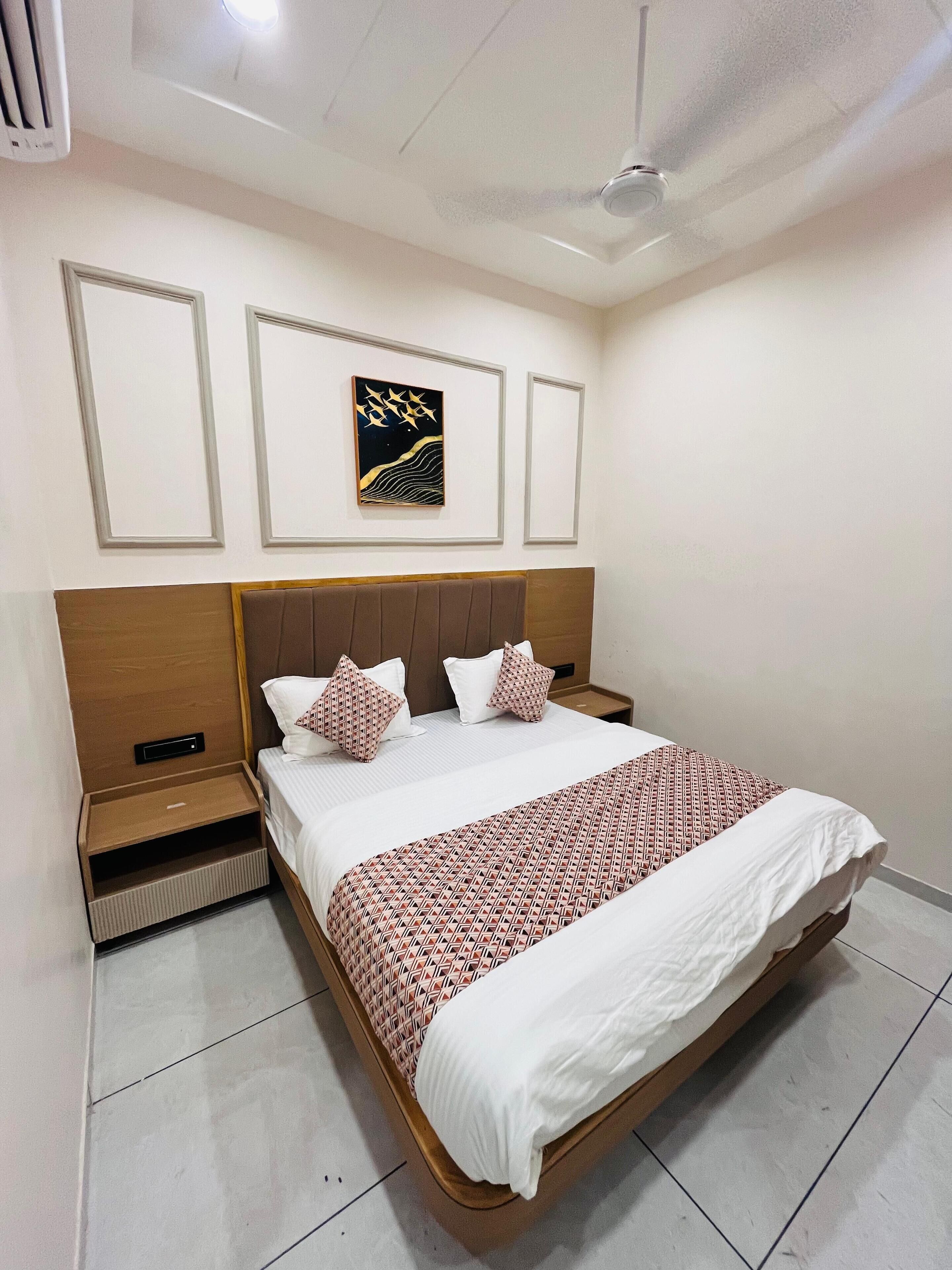 Une chambre bien rangée, avec un lit, des tables de chevet et un ventilateur de plafond.