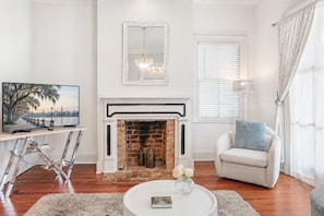 A living room with a fireplace, a television, and a sofa.