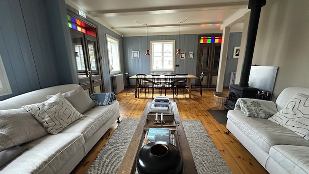 A spacious living room with a sofa, coffee table, and a dining area with chairs and a table. - Gamla Apótekið (The Old Pharmacy)  in heart of Akureyri - Main apartment (Akureyri)