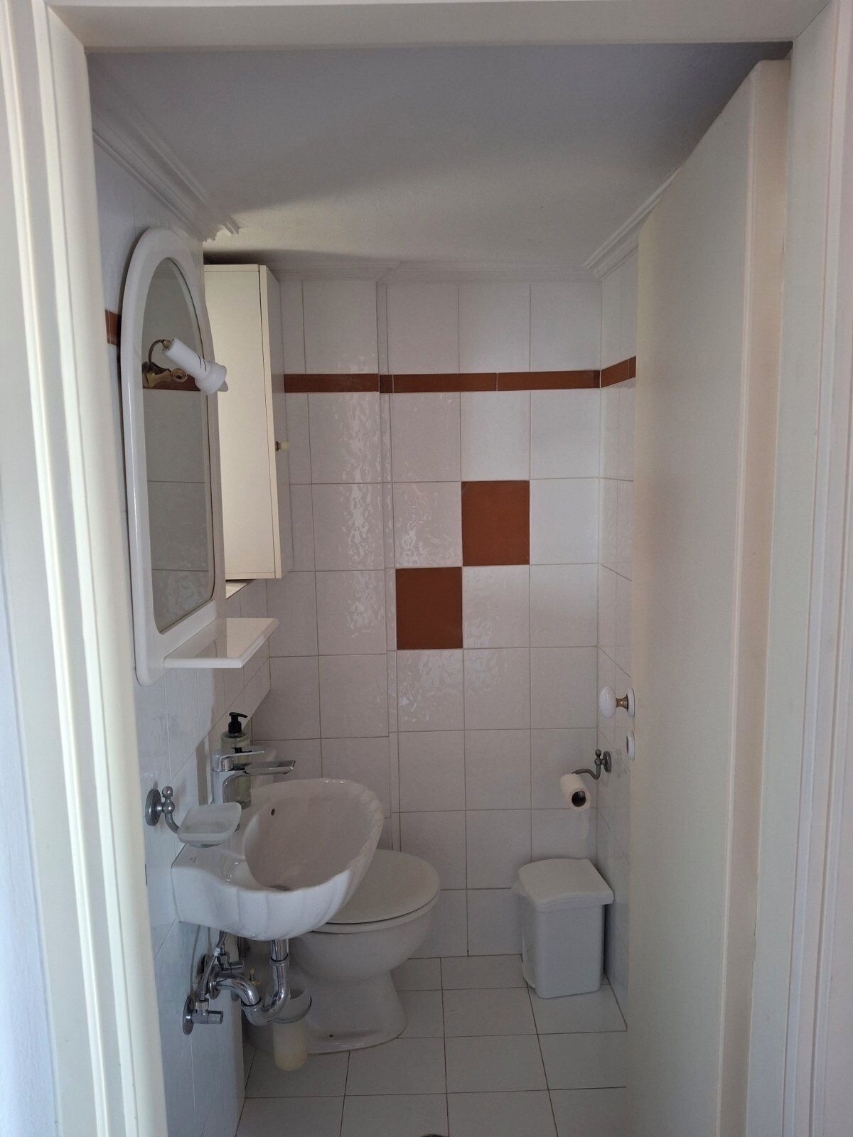A bathroom with a sink, toilet, and shower area.