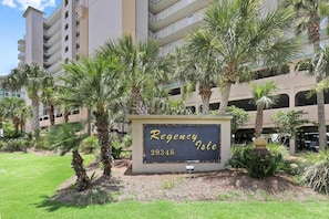 A sign for "Regency Isle" with the number 29348, surrounded by palm trees and a building in the background.