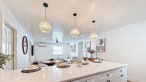A spacious kitchen with a large island, pendant lighting, and a ceiling fan.
