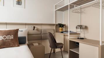 Una habitación de hotel con cama, escritorio, silla, armario y mesita de noche.