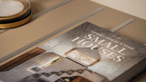 Un libro titulado 'Homes for Our Time Small Houses' sobre una mesa.