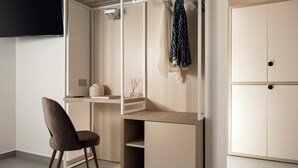 Una habitación moderna con escritorio, silla, armario y televisor.