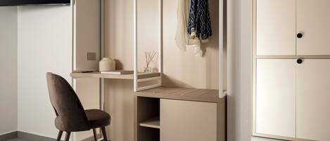 Una habitación moderna con escritorio, silla, armario y televisor.