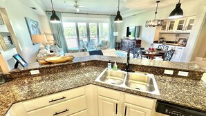 A modern kitchen with granite countertops, white cabinets, and a dishwasher. - Great view Near the beach with a golf cart 5353PR (Miramar Beach)