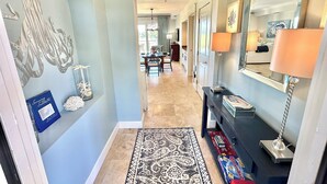 A hallway with a patterned rug, a dark console table with lamps, and a decorative wall piece. - Great view Near the beach with a golf cart 5353PR (Miramar Beach)