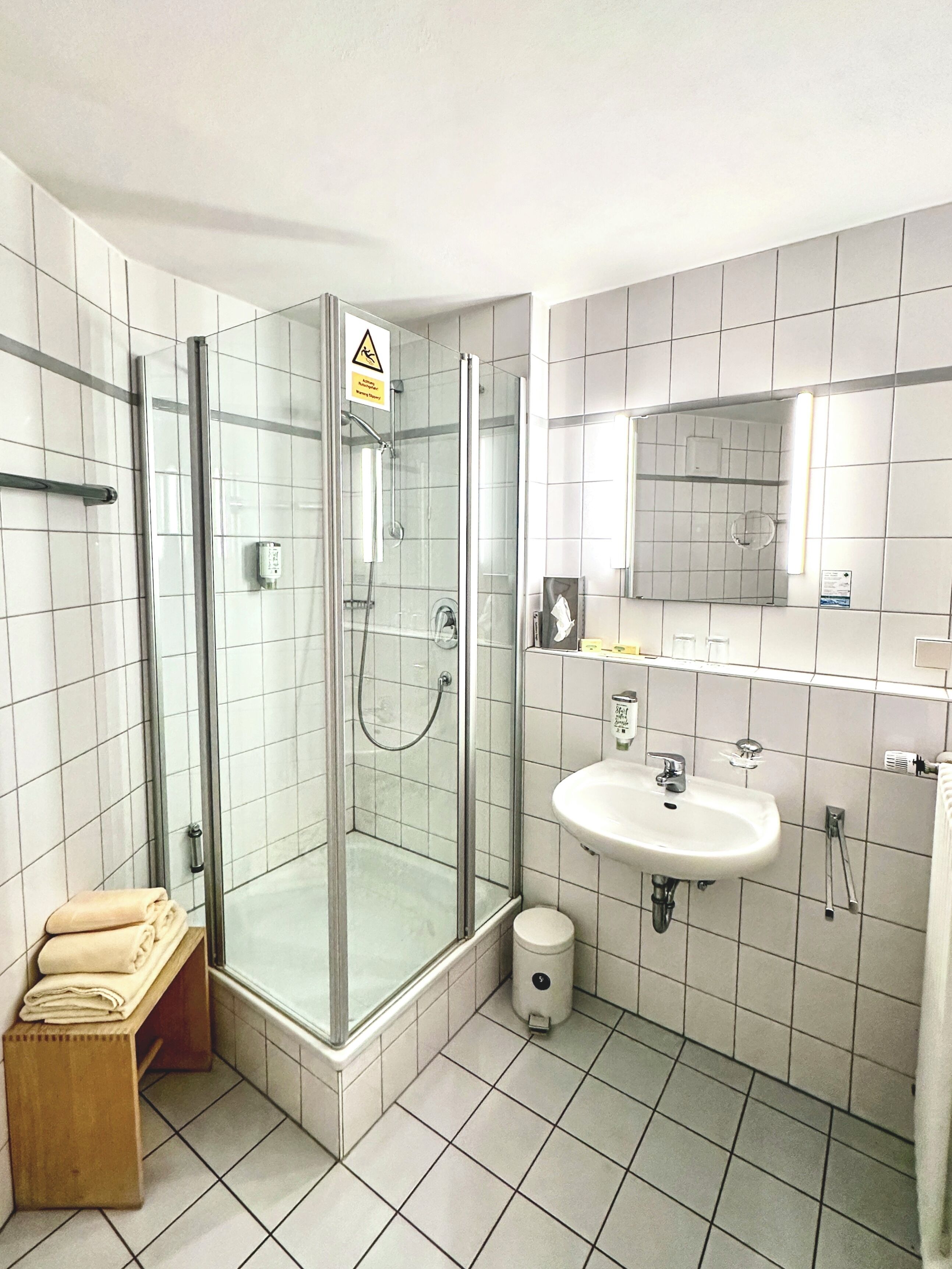 A modern bathroom with a glass-enclosed shower, a sink, and a toilet.