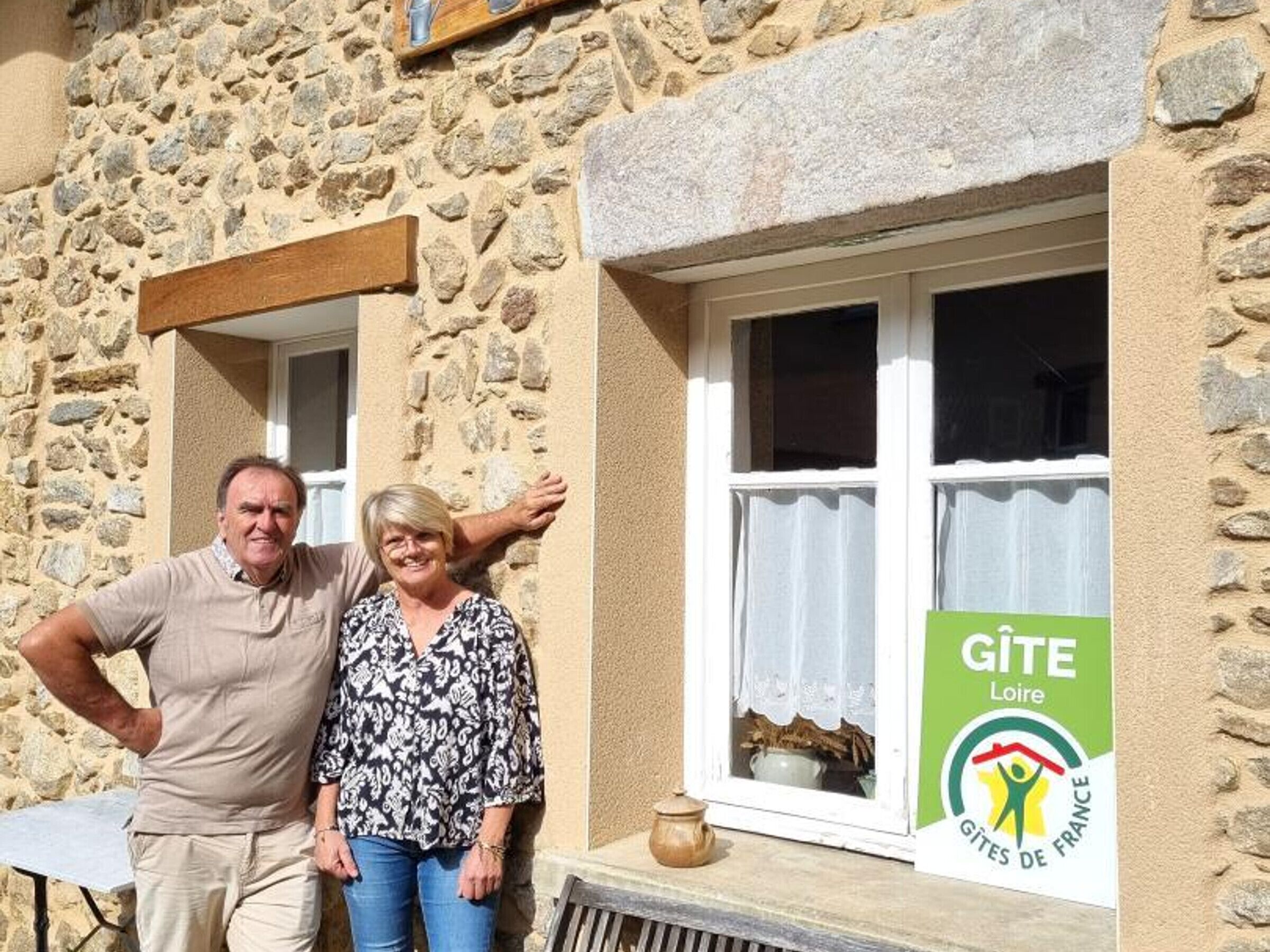A stone building with a window and a GITE Loire sign.
