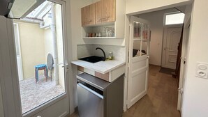 Una cocina compacta con lavavajillas, un fregadero y armarios de madera.