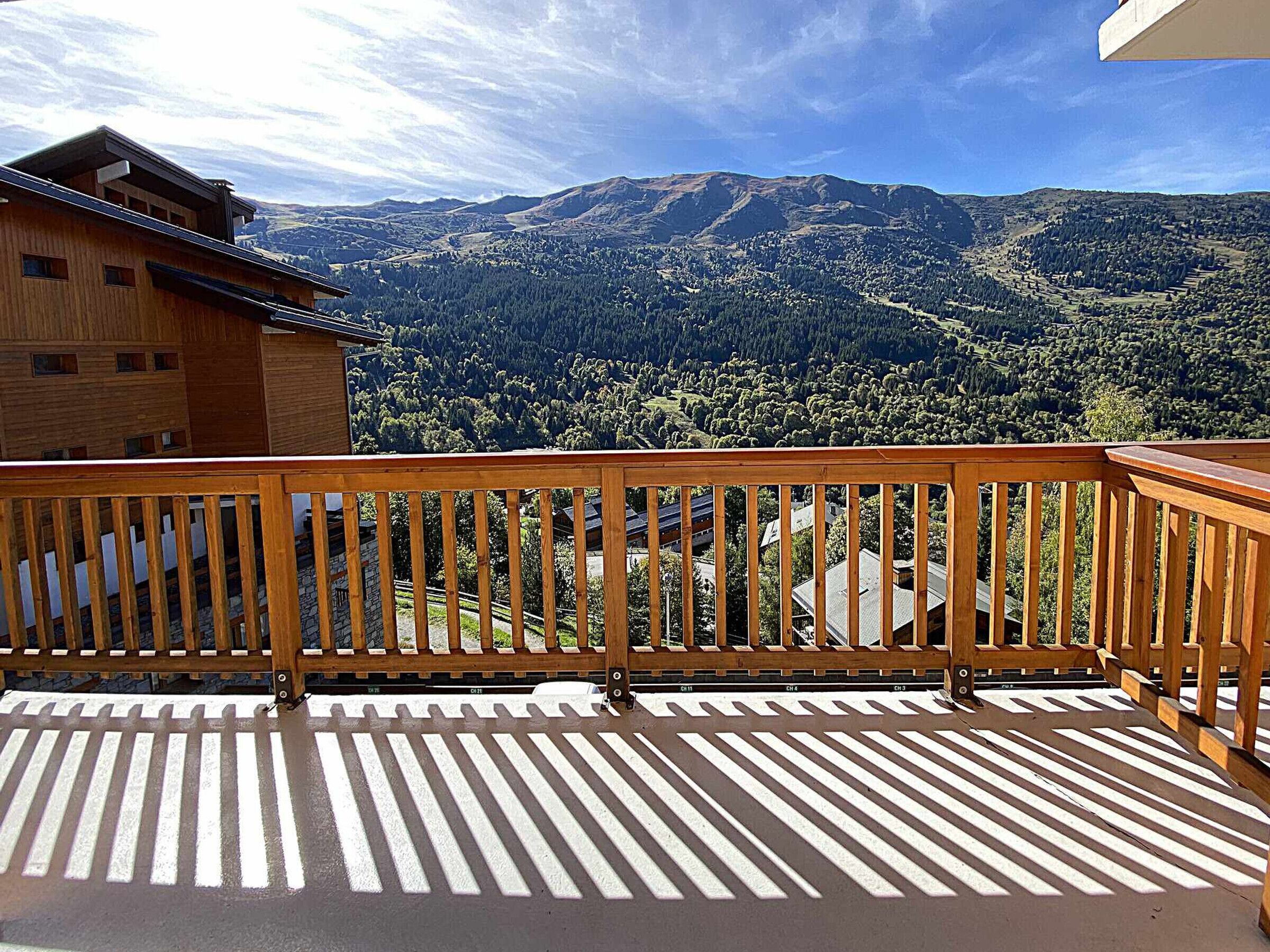 Ein Holzbalkon mit Blick auf eine gebirgige Landschaft.