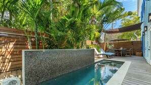 A swimming pool with a mosaic wall, surrounded by wooden decking and tropical plants. - THE BLUE PINEAPPLE ~ Old Town 4 BR/4.4 Bath Home w/ Private Pool & Parking! (Key West)