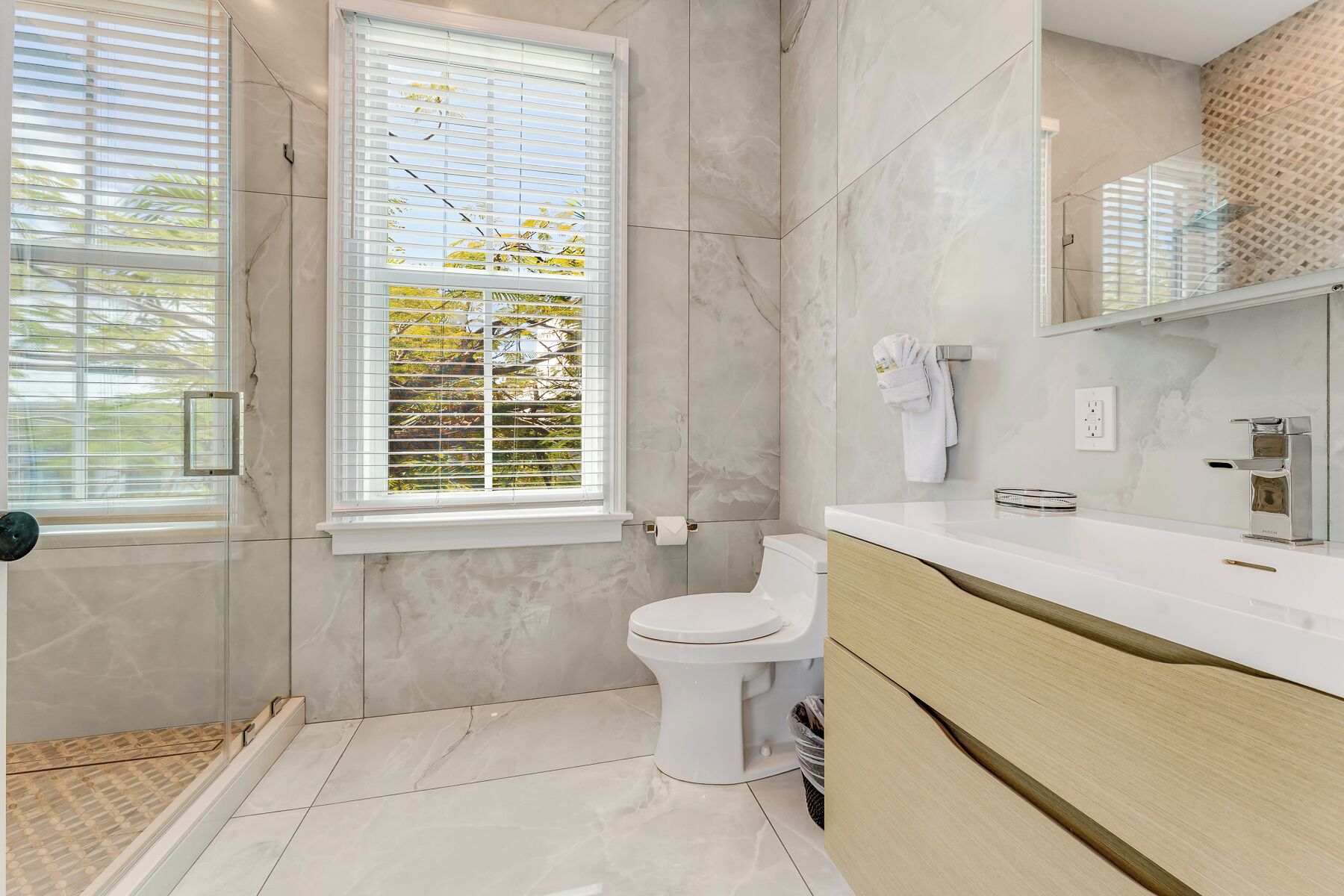 A modern bathroom with a toilet, a sink, and a shower area.
