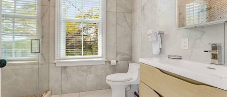 A modern bathroom with a toilet, a sink, and a shower area.