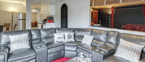 A modern living room with a sectional sofa, a coffee table, and a red rug.