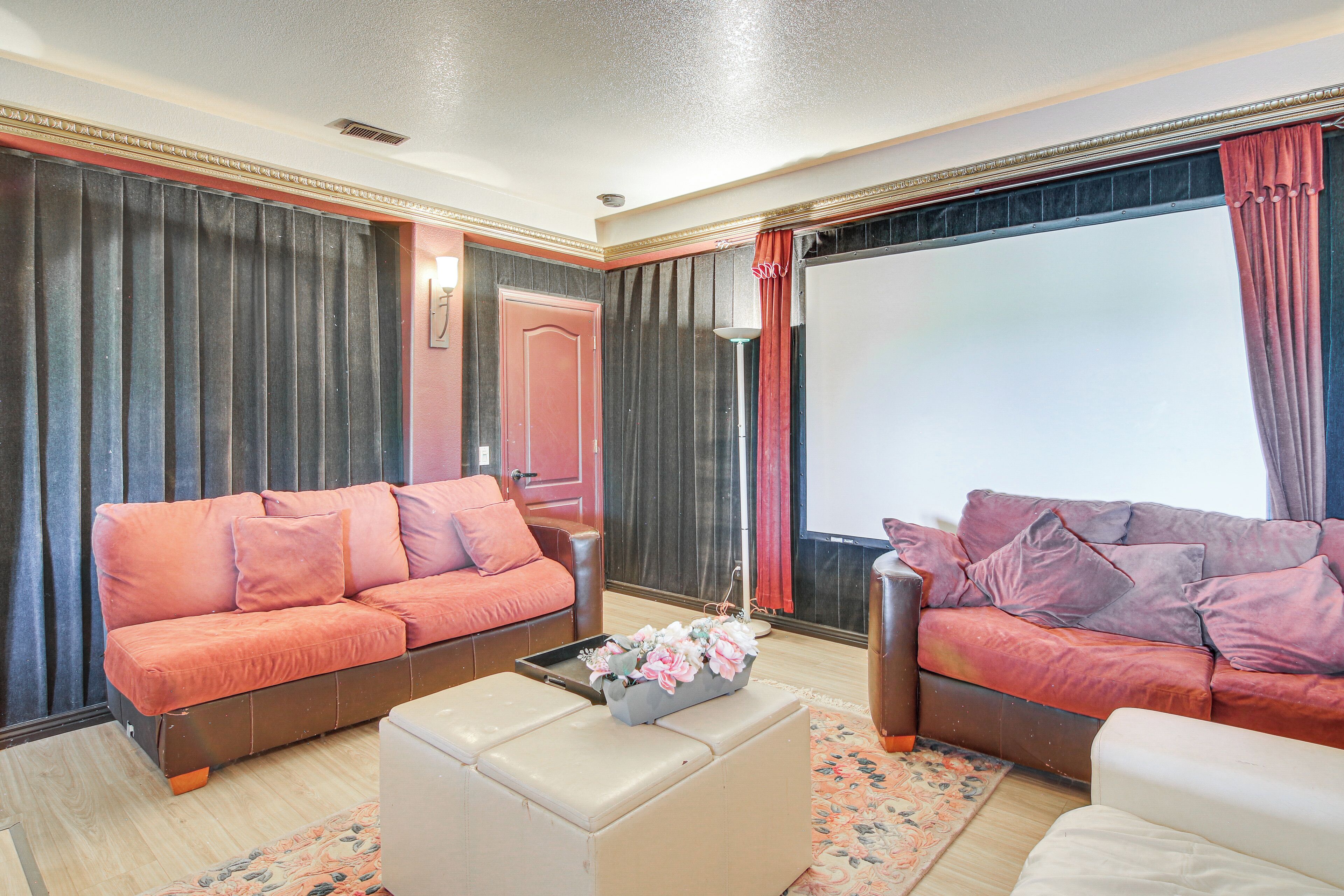 Una sala de estar con dos sofás, una mesa de centro y un ventanal con cortinas.
