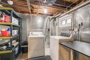 A laundry room with two washing machines, shelves with cleaning supplies, and a window. - 1 Mi to Old Town Alexandria: Townhome w/ Patio (Alexandria)