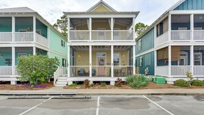 A two-story building with a balcony, a porch, and a small garden area. - Steps to Sea! Cottage w/ Pools in Port St Joe (Port St. Joe)