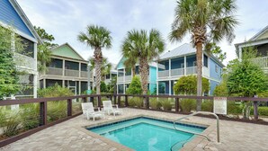 A pool area with lounge chairs and a sign indicating spa rules. - Steps to Sea! Cottage w/ Pools in Port St Joe (Port St. Joe)