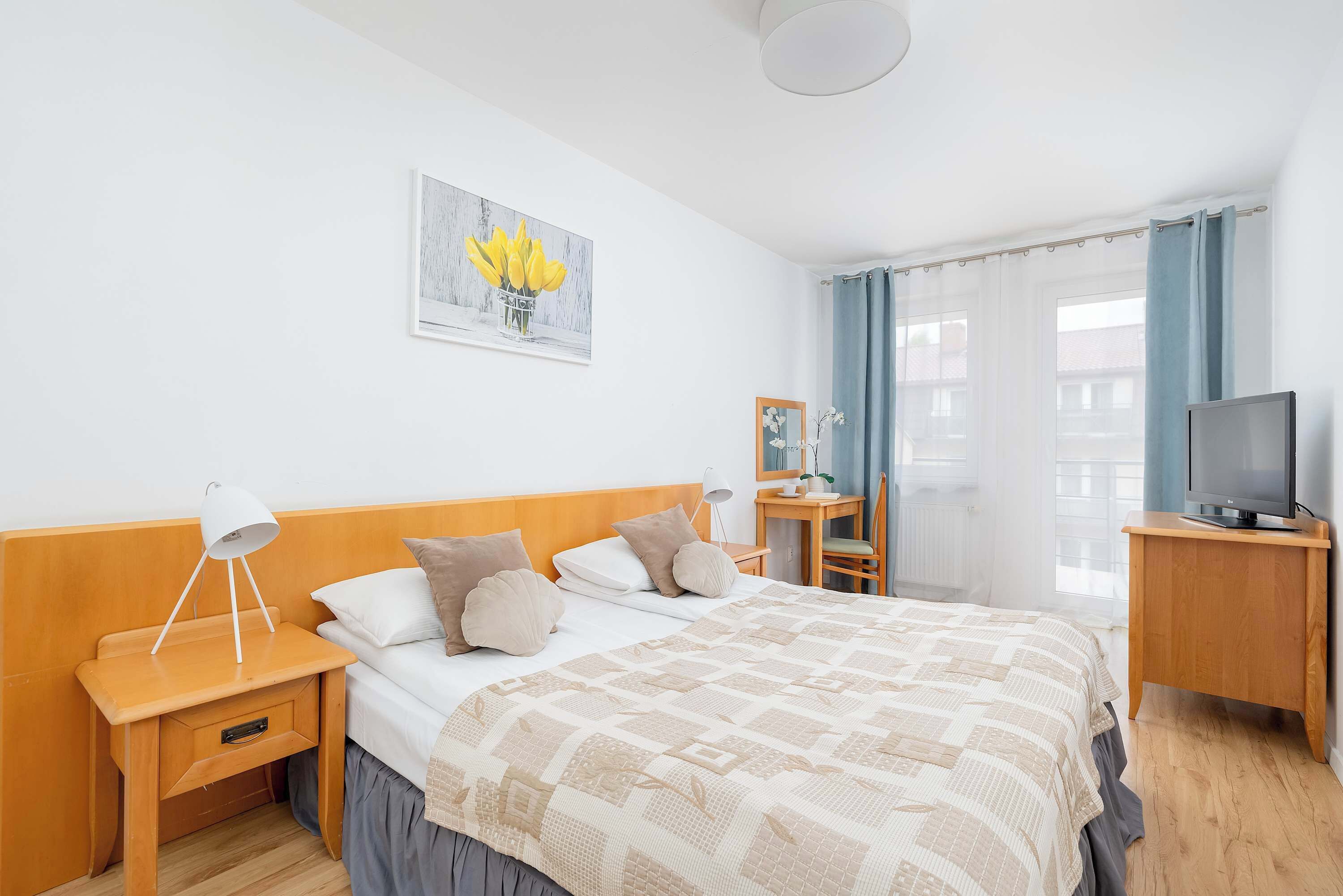 Une chambre d’hôtel comprenant un lit, des tables de chevet, une télévision, un bureau et une chaise.