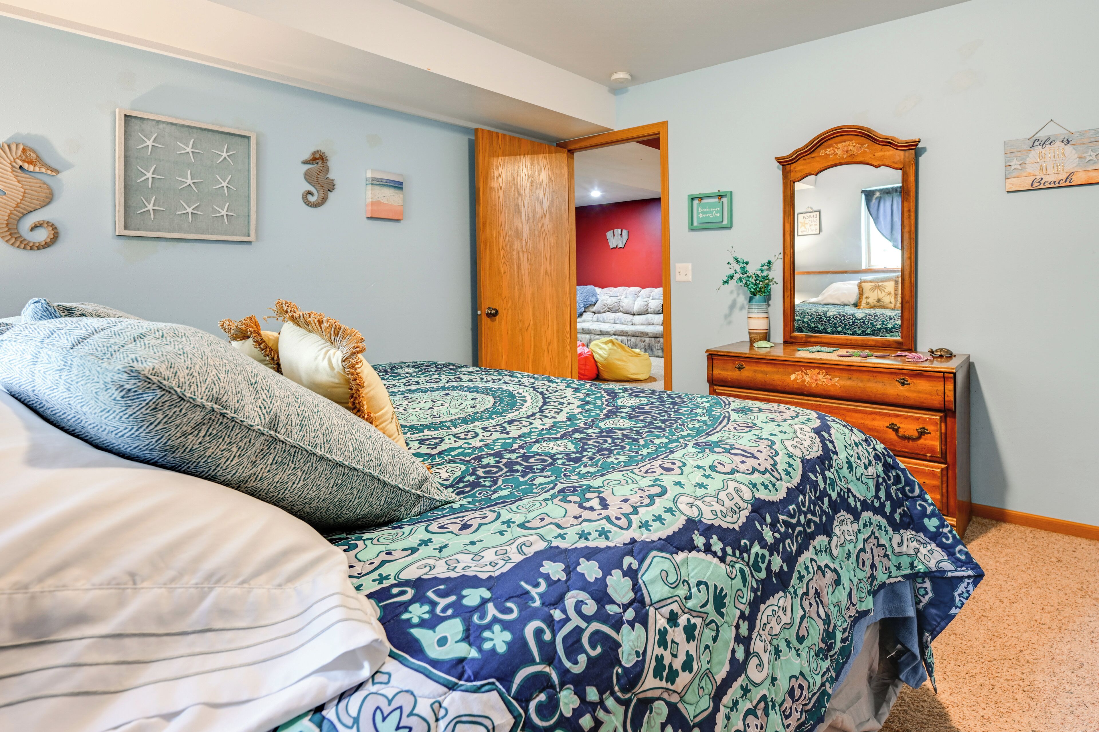 Ein Schlafzimmer mit Bett, Kommode und Spiegel.