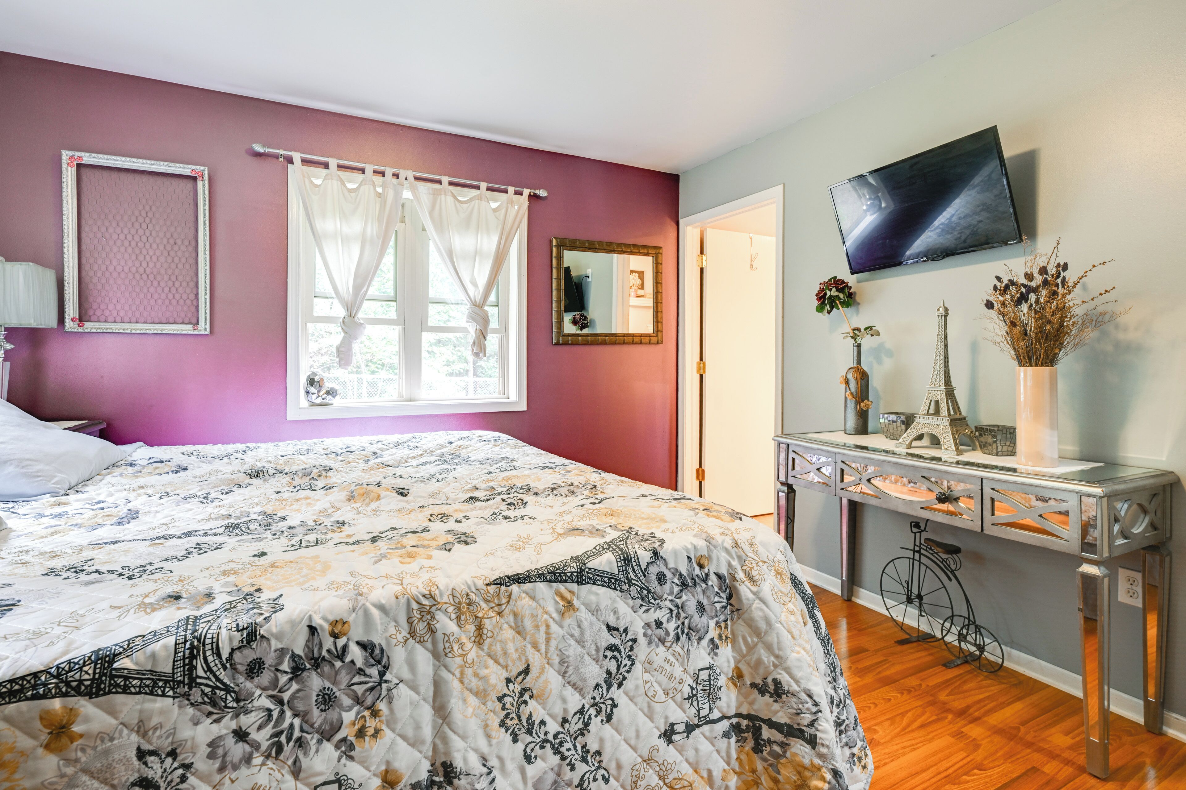 Un dormitorio con cama, cómoda, espejo y televisor.