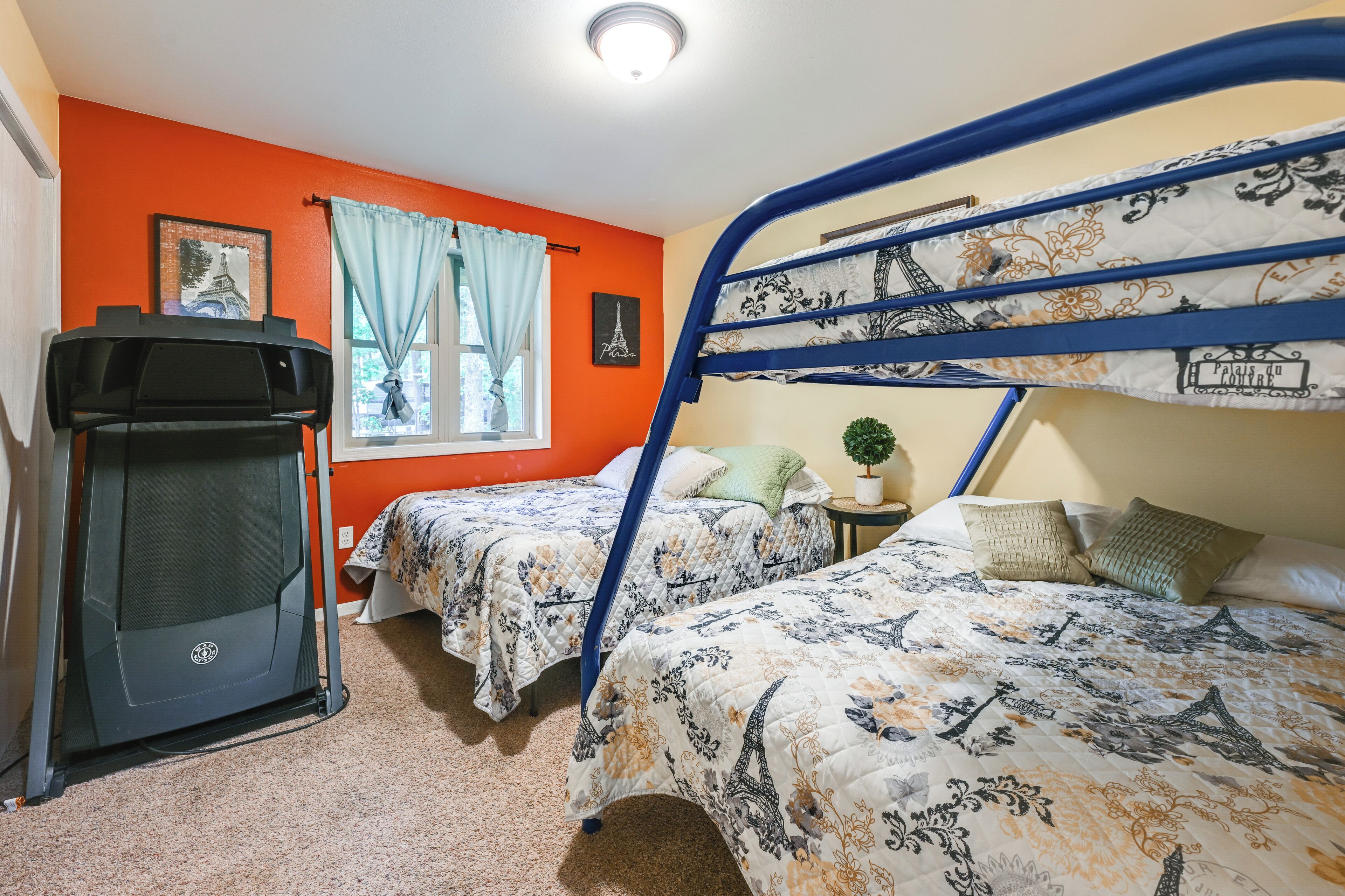 A room with two beds, a desk, and a television.