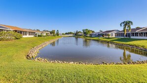 A residential area with a pond, houses with white exteriors, and a clear blue sky. - Pool Access: Condo 4 Mi to Bradenton Riverwalk! (Bradenton)