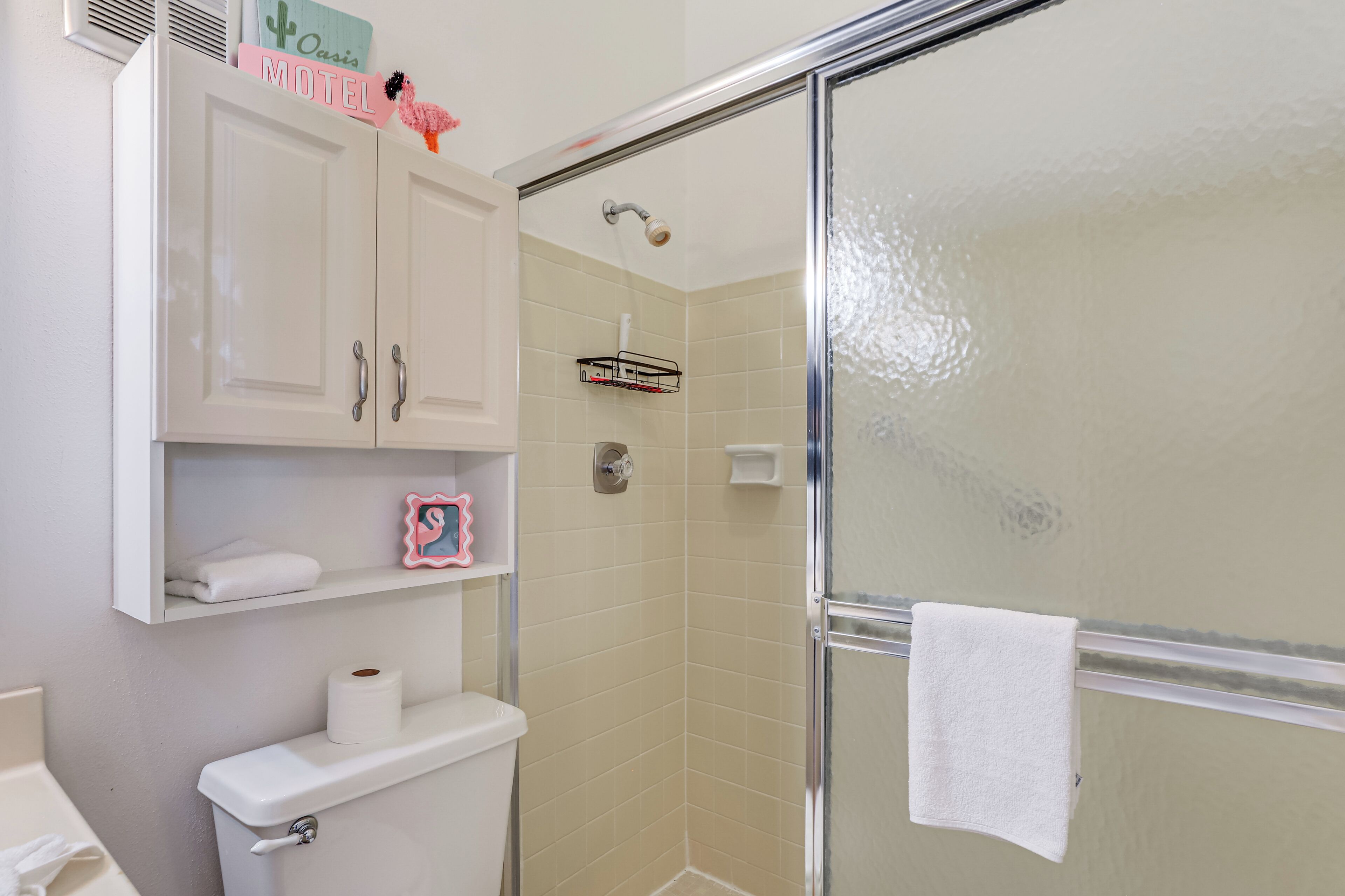 A bathroom with a toilet, a shower, and a sink.