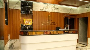 A reception desk with a marble top and a wooden backdrop. - The White Castle Hotel  (Mysore)