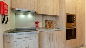 Une cuisine avec des meubles de rangement en bois, une hotte de cuisinière en acier inoxydable, un four à micro-ondes et un évier.
