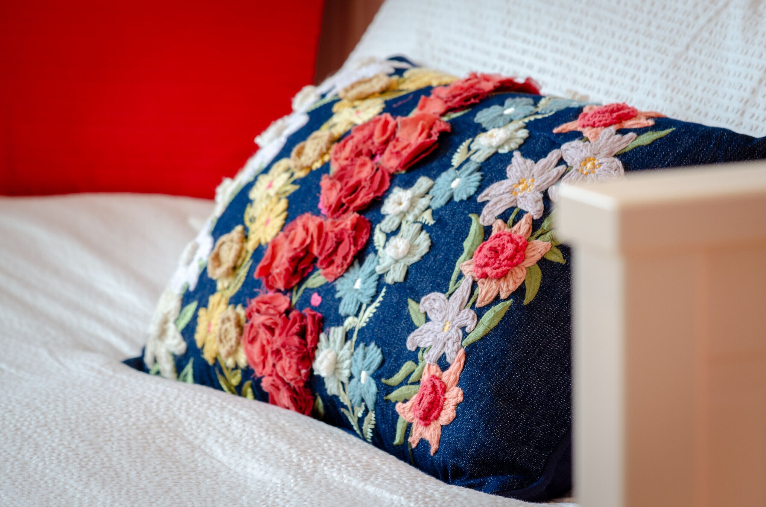 Ein Bett mit einem blumigen Kopfkissen und einem weißen Kissen.