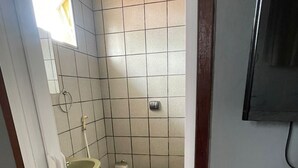 A small bathroom with a toilet, sink, and shower. - Pousada Zenite (Natal)