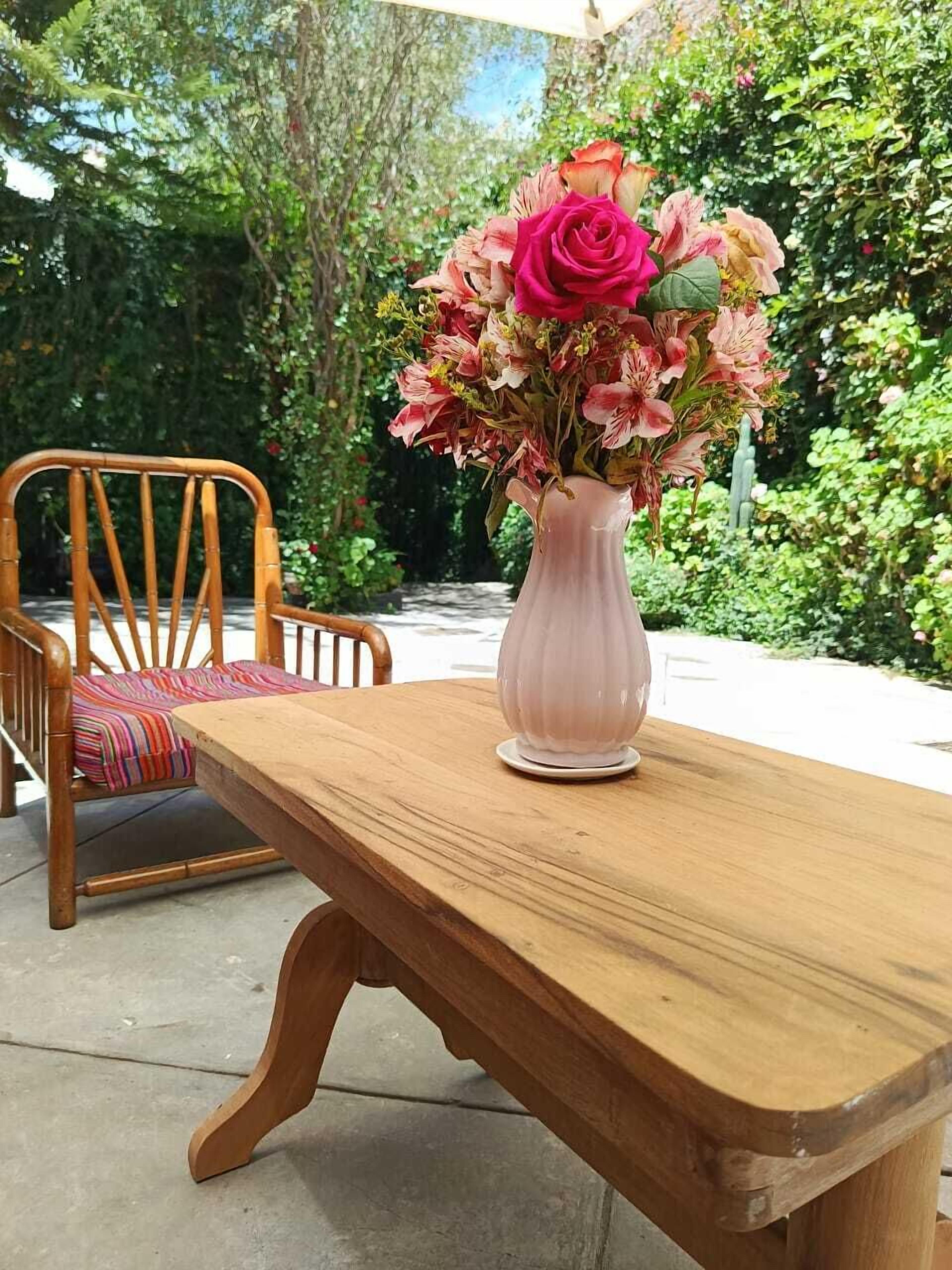 Une table en bois avec un vase de fleurs.