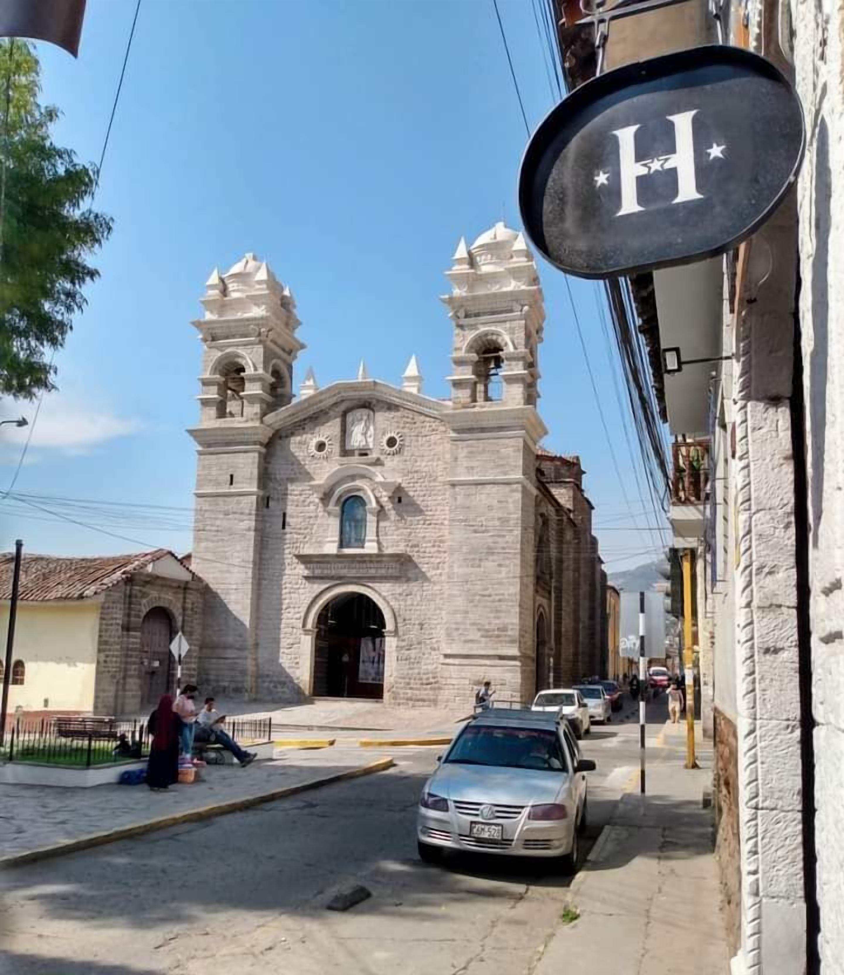 Eine historische Kirche mit zwei Glockentürmen und einer Straße davor.