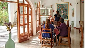 Un comedor con un amplio arco, sillas de madera y una mesa dispuesta para una comida.