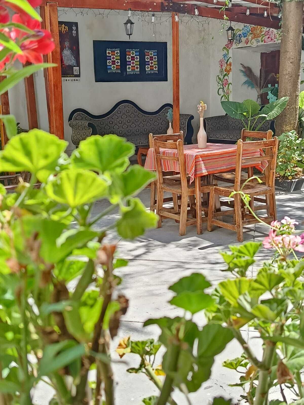 A wooden table with chairs, a patterned wall, and a decorative lantern.