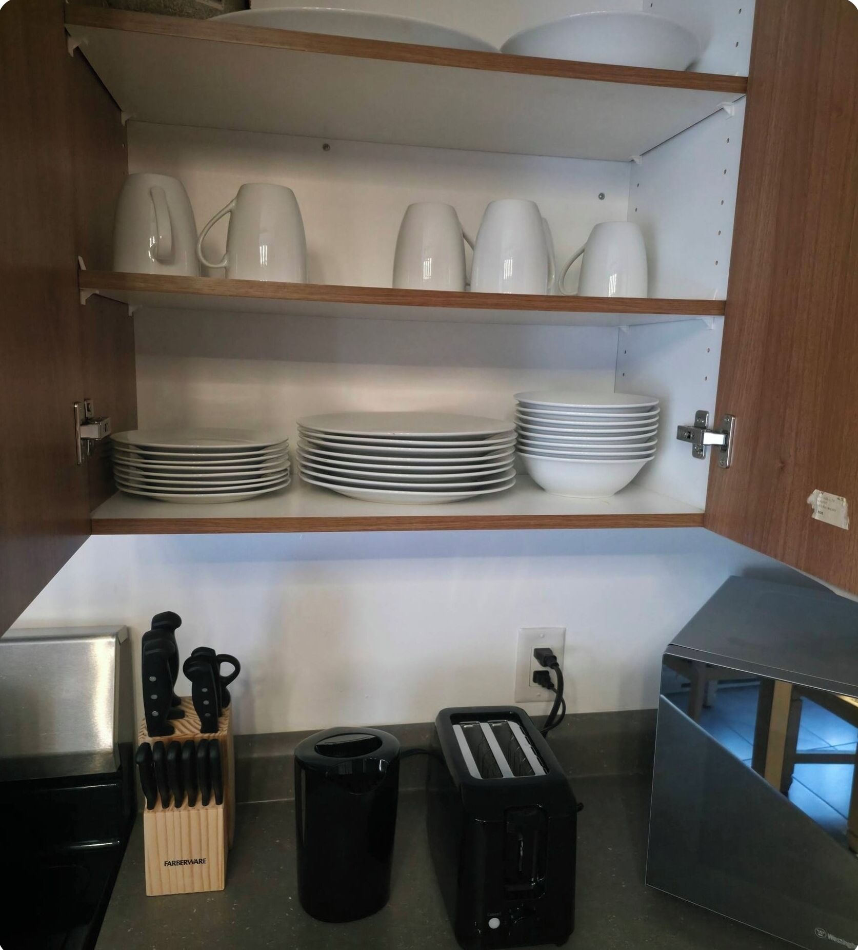 A kitchen with a countertop, a toaster, a coffee maker, and a knife block.