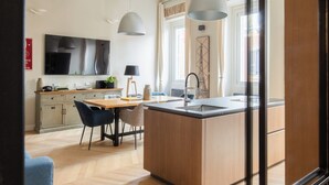 A modern kitchen with a central island, wooden flooring, and pendant lighting. - THE BREAK - CAMPO MARZIO MAISON DELUXE (Roma)